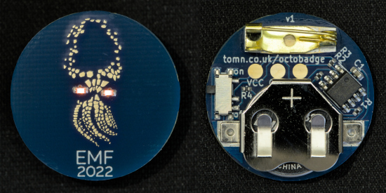 badge front and back -- blue circular PCBs with an illustration of a baby octopus and the text "EMF 2022"